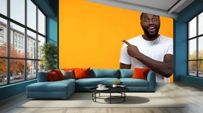 Excited black man pointing finger into background, template for text, attention Wall mural