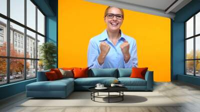 Excited business woman showing success gesture orange background, career goal Wall mural