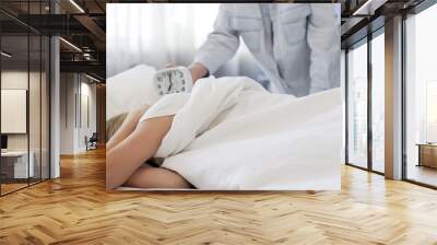 Father showing daughter clock, oversleeping, refusing to get up in morning Wall mural