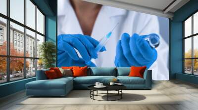 Female doctor holding syringe with medication, first aid, lab vaccine studies Wall mural