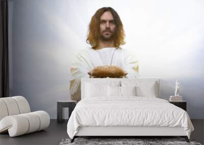 Jesus holding bread on illuminated background, sacramental food in religions Wall mural