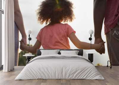 Little girl holds fathers and mothers hands, happiness and wellbeing in family Wall mural