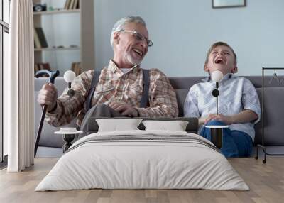 Old man and boy laughing genuinely, joking, valuable fun moments together Wall mural