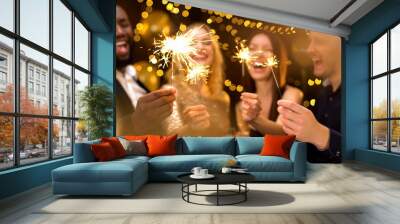 Overjoyed young people celebrating new year, holding bengal lights, having fun Wall mural