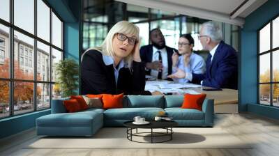 Overworked business lady tired of stressful job, colleagues arguing background Wall mural