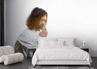 Religious man praying to God, light falling as sign of forgiveness, God mercy Wall mural