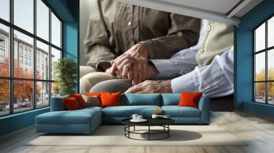 Retiree male and female sitting on sofa, woman holding man hand support and care Wall mural