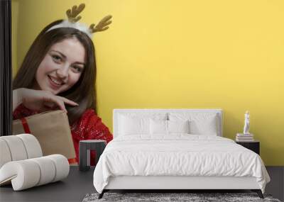 Close-up portrait of a girl with gifts in her hands. Wall mural