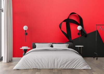 Black shopping bag on a red background. Wall mural