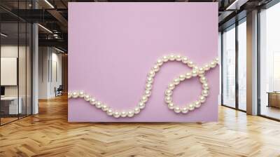 Elegant pearl necklace on purple background, top view. Space for text Wall mural