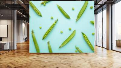 Fresh green peas on blue background. Flat lay Wall mural