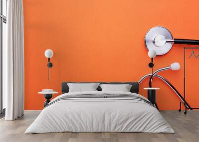 Medical stethoscope on orange background. Health care concept Wall mural