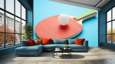 Ping pong paddle with ball on blue. Table tennis racket. Wall mural