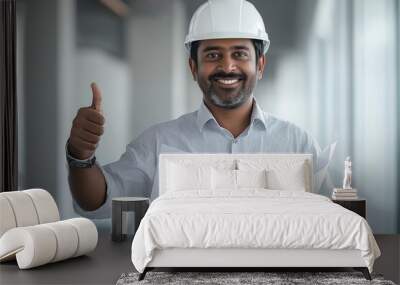 Confident Indian architect with construction plans giving thumbs up in industrial setting. Wall mural