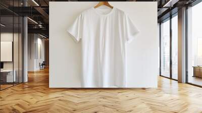 Minimalist White T-Shirt Mockup Hanging on Wooden Hanger Against Plain Background Wall mural