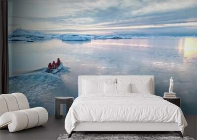 Antarctica travel and exploration, people riding motor boat. Zodiac boat sailing cold polar ocean water surface in sunset light. Discover the beauty of South Pole. Aerial winter landscape, drone Wall mural