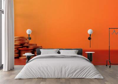 A stack of coins resting on a smooth surface with a warm orange background, symbolizing wealth and investment opportunities. Wall mural