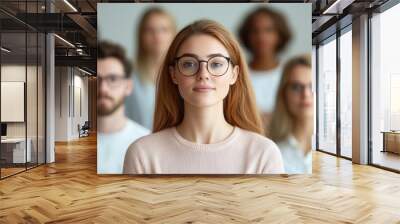 group of diverse individuals participating in virtual meeting, with focus on woman in foreground wearing glasses. setting conveys sense of collaboration and engagement Wall mural