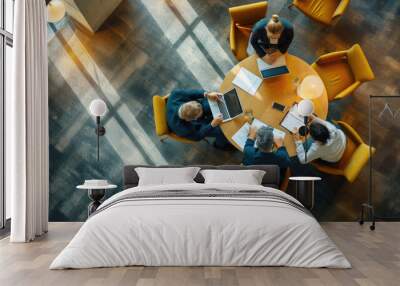 Aerial view of a professional meeting with four individuals around a round table Wall mural