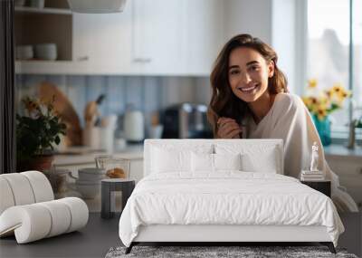 Beautiful woman smiling with a cup of coffee in the kitchen of her home Wall mural