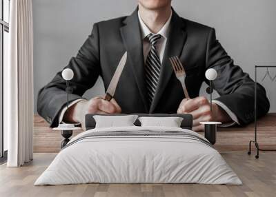 Businessman holding fork with knife and ready to eat. Concept of competition in business Wall mural