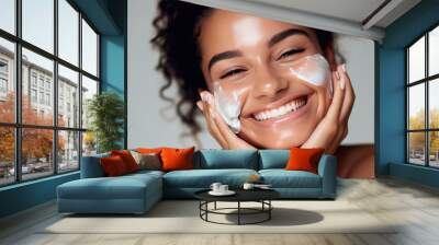 Close up beauty portrait of a laughing beautiful half naked woman applying face cream isolated over grey background. Created with Generative AI technology. Wall mural