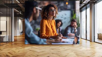 Close-up of a business meeting with several individuals over a wooden table, suggesting a modern, tech-savvy professional environment. Wall mural