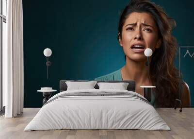 Depressed young woman crying on blue background Wall mural