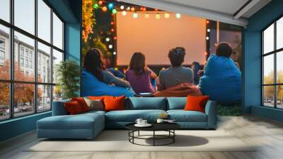 Group of friends from behind, sitting and enjoying an outdoor movie night with a blank screen, surrounded by garden lights at dusk. Wall mural