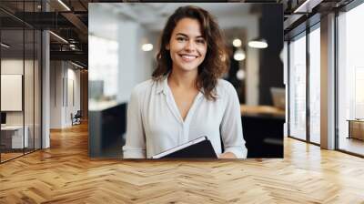 Happy professional female psychologist holding clipboard, looking and smiling at camera. Wall mural