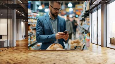 man in a blue blazer and glasses is using his smartphone while shopping in a grocery store Wall mural