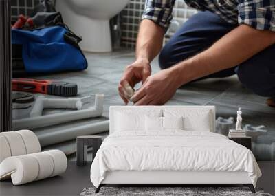 Plumber at work, fitting pipes on a bathroom floor with various plumbing tools Wall mural