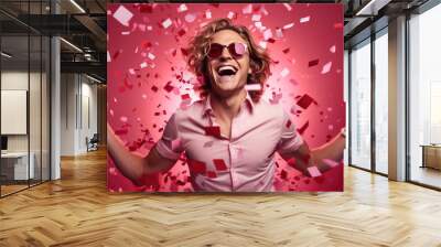 Portrait of a laughing man surrounded by a red confetti paper hearts against a pink background. Wall mural