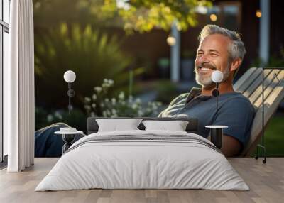 Relaxed man sits in a chair in the backyard of his home Wall mural