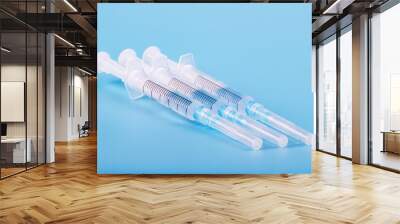 Several syringe on blue background prepared for injection in hospital Wall mural