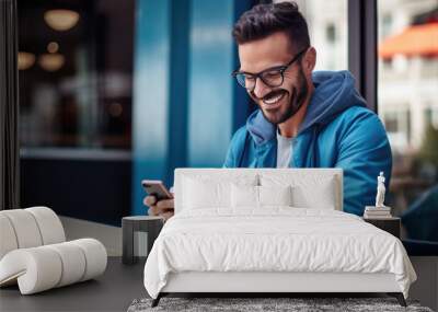 Smiling man in blue clothes is using the phone Wall mural