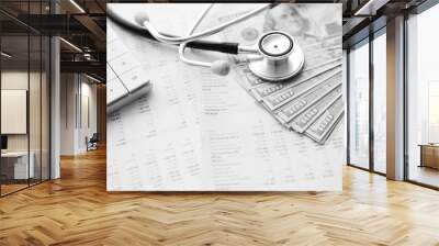 Stethoscope, calculator and money cash on medical data. Concept of health care costs or medical insurance Wall mural