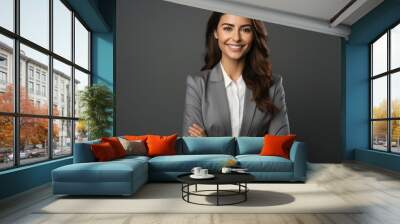 Successful businesswoman with crossed arms stands on a gray background. Wall mural