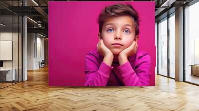 Thoughtful child on pink background looking away. Wall mural