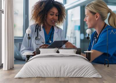 two female healthcare professionals are looking at a tablet Wall mural