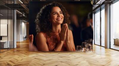 Young beautiful woman claps her hands at a restaurant event. Wall mural