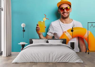 young man with a beaming smile, wearing sunglasses and a straw hat, holding a glass of orange juice, giving a thumbs up, and wearing a lifebuoy Wall mural