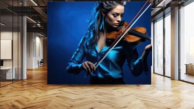 Young woman playing violin on blue background Wall mural