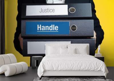 Handle – Lawyer carries a stack of 3 file folders. One folder has the label Handle. Symbol for law, justice, judgement Wall mural