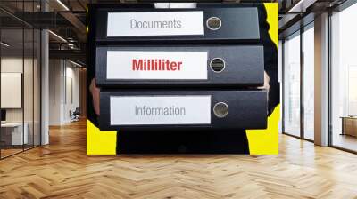 Milliliter – finance/economics. Man carries a stack of 3 file folders. A folder has the label Milliliter. Business, statistics concept Wall mural