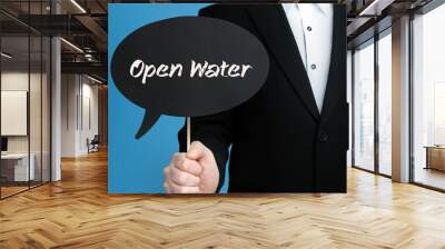 Open Water. Businessman in suit holds speech bubble at camera. The term Open Water is in the sign. Symbol for business, finance, statistics, analysis, economy Wall mural