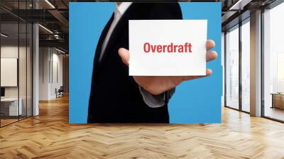 Overdraft. Business man in a suit holds card at camera. The term Overdraft is in the sign. Symbol for business, finance, statistics, analysis, economy Wall mural