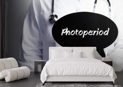 Photoperiod. Doctor in smock holds up speech bubble. The term Photoperiod is in the sign. Symbol of illness, health, medicine Wall mural