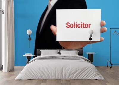 Solicitor. Business man in a suit holds card at camera. The term Solicitor is in the sign. Symbol for business, finance, statistics, analysis, economy Wall mural