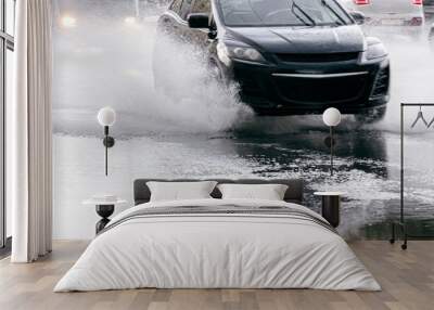 blurred black car on wet road with water pools during downpour Wall mural